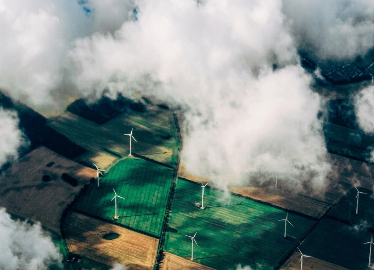 Wind turbines across green fields representing GONEO green power use
